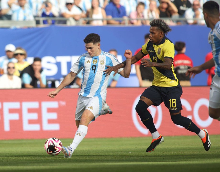 El delantero argentino Julián Álvarez (i) fue registrado este domingo, 9 de junio, al disputar un balón con Joao Ortiz (d), de Ecuador, durante un partido amistoso disputado en el estadio Soldier Field de Chicago (Illinois, EE.UU.). EFE/Trent Sprague