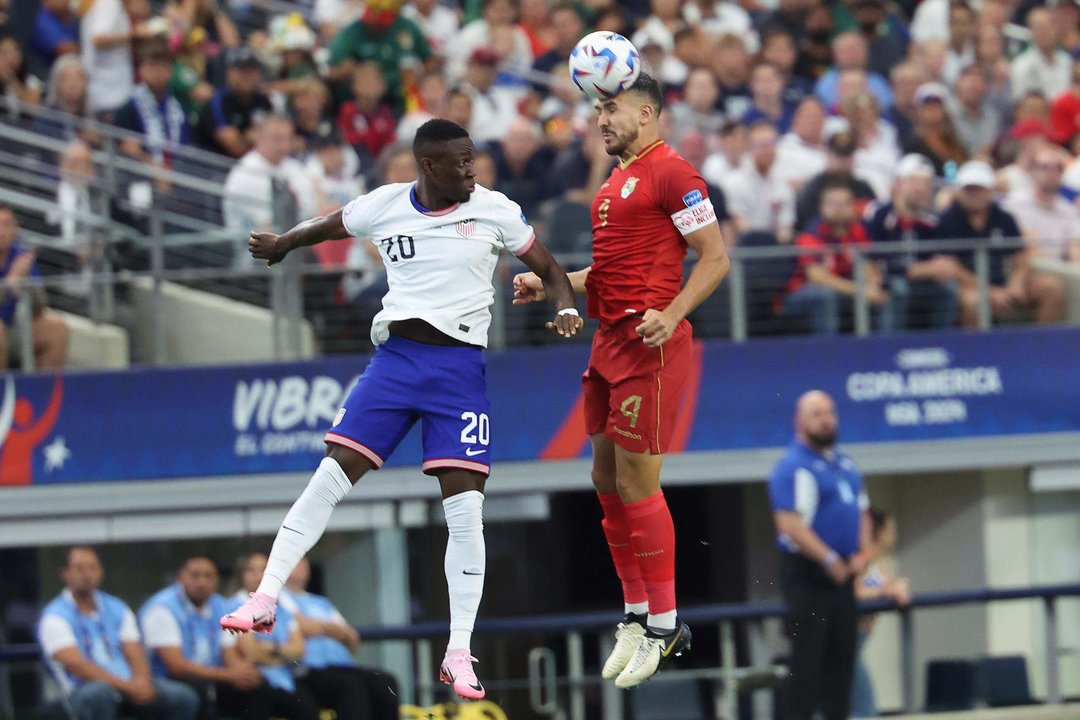 El atacante estadounidense Folarin Balogun (i) fue registrado este domingo, 23 de junio, al disputar un balón con el defensa boliviano Luis Haquín (d), durante el primer partido del grupo C de la Copa América, en el estadio AT&T de Arlington (Texas, EE.UU.). EFE/Kevin Jairaj