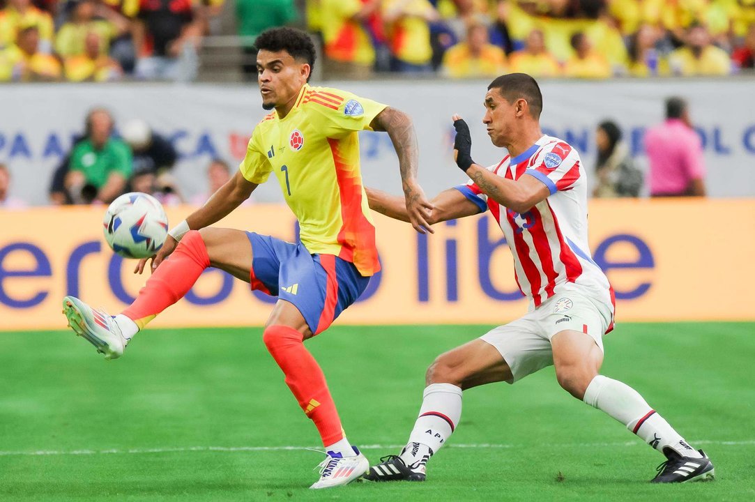 El delantero colmbiano Luis Díaz (i) fue registrado este lunes, 24 de junio, al disputar un balón con el defensor paraguayo Gustavo Velázquez (d), durante el primer partido del grupo D de la Copa América, en el estadio NRG de Houston (Texas, EE.UU.). EFE/Leslie Plaza