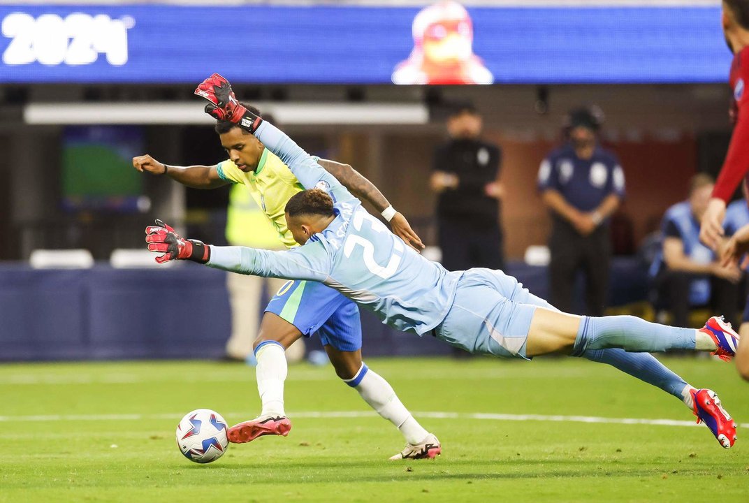 El guardameta de Costa Rica, Patrick Sequeira (d), fue registrado este 24 de junio al intentar frenar el avance del delantero brasileño Rodrygo, durante un partido del grupo D de la Copa América, en el Sofi Stadium de Inglewood (California, EE.UU.). EFE/Caroline Brehman