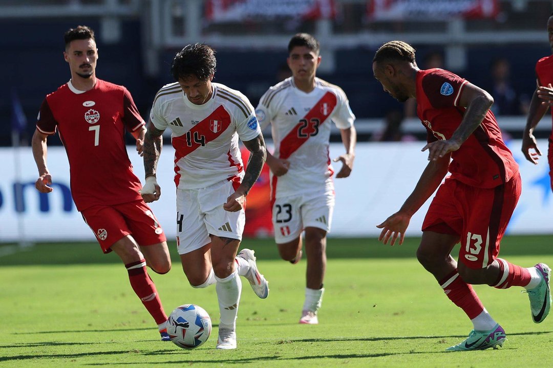 El centrocampista canadiense Stephen Eustaquio (i) fue registrado el pasado 25 de junio al disputar un balón con el atacante peruano Gianluca Lapadula (c), durante un partido del grupo A de la Copa América, en el estadio Children's Mercy Park de Kansas City (Misuri, EE.UU.). EFE/William Purnell