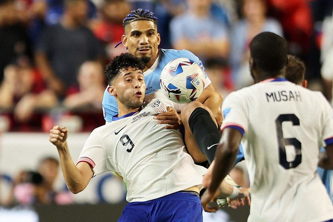 El defensa uruguayo Ronald Araujo (atrás) fue registrado este lunes, 1 de julio, al disputar un balón con el atacante estadounidense Ricardo Pepi, durante el partido final del grupo C de la Copa América 2024, en el estadio Arrowhead de Kansas City (Misuri, EE.UU.). EFE/William Purnell