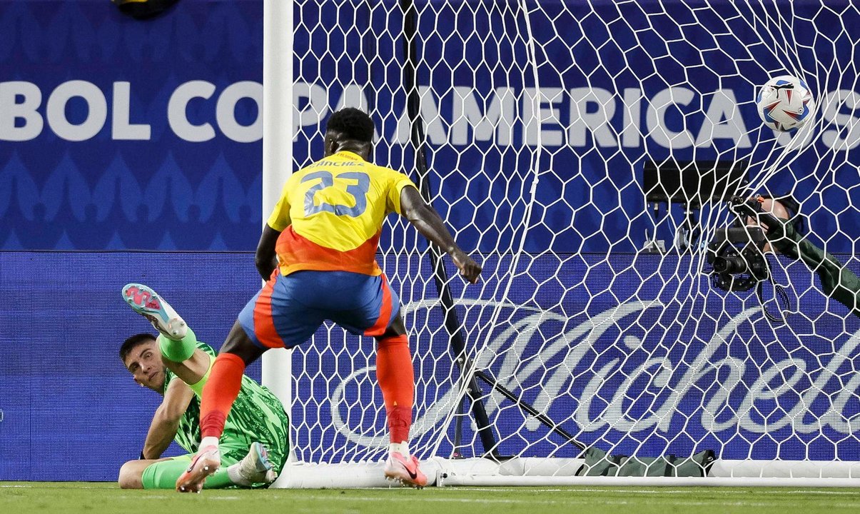 El defensor colombiano Davinson Sánchez fue registrado este miércoles, 10 de julio, al observar el gol que su compañero Jefferson Lerma (fuera de cuadro) le anotó a portero uruguayo Sergio Rochet (i), durante la segunda semifinal de la Copa América 2024, en el estadio Bank of America de Charlotte (Carolina de Norte, EE.UU.). EFE/Erik S. Lesser