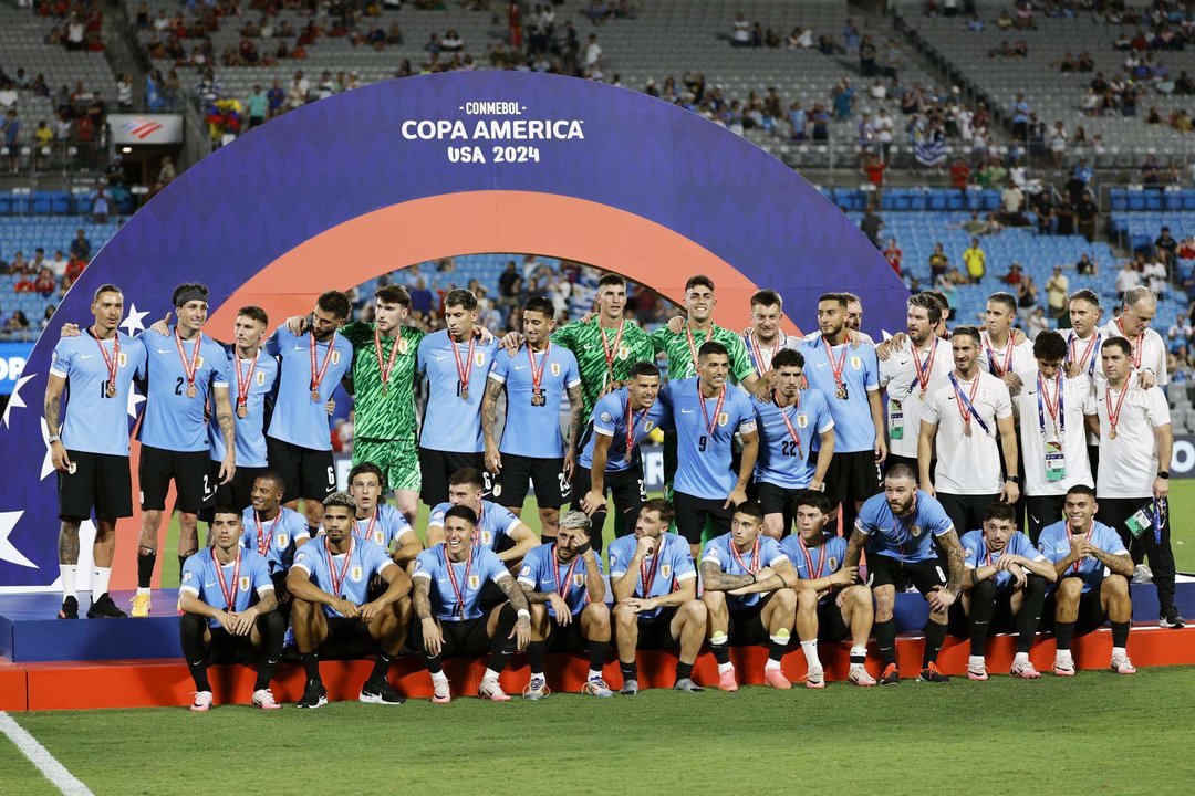 Integrantes de la selección uruguaya de fútbol fueron registrados este sábado,13 de julio, al posar con la medalla del tercer puesto de la Copa América 2024, luego de imponerse a Canadá en la definición de cobros penales y tras empatar 2-2 en el penúltimo partido de la edición 48 del certamen, en el estadio Bank of America de Charlotte (Carolina del Norte, EE.UU.). EFE/Erik S. Lesser